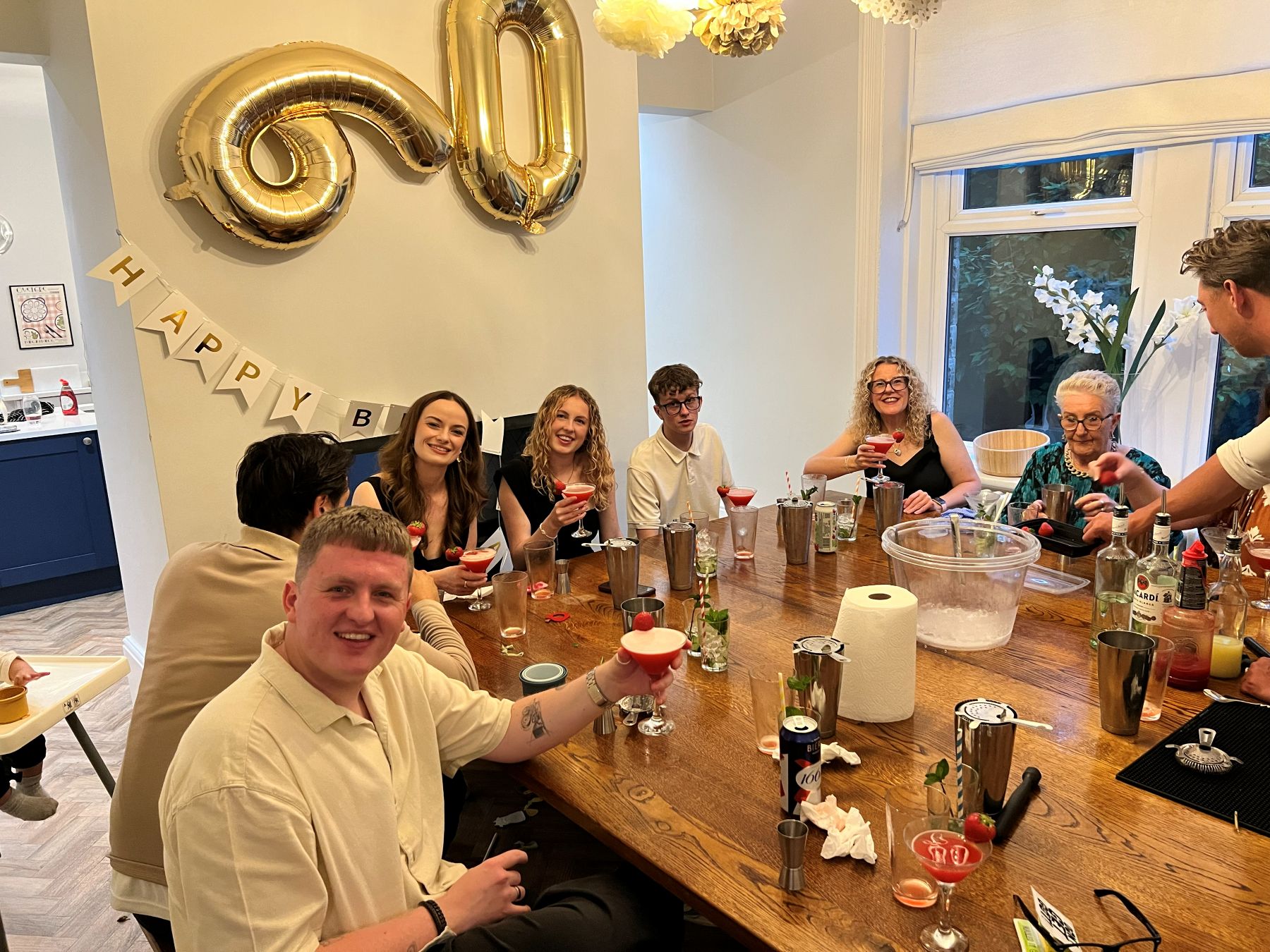 A big group toasting the cocktails they made at a celebration
