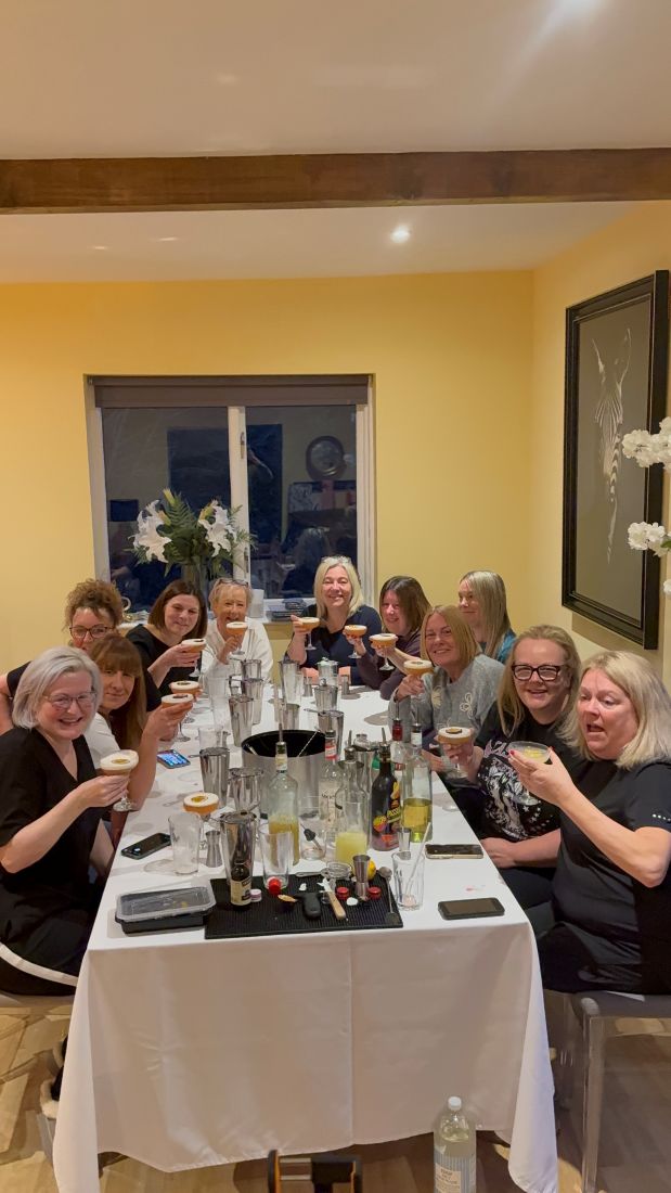 A group raising their glasses together at a birthday masterclass