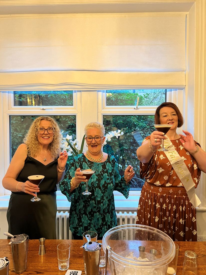 Three friends laughing with the espresso martinis they have just made
